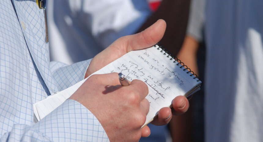 reporter writing in notebook