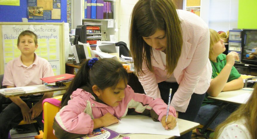 Teacher helping student in classroom