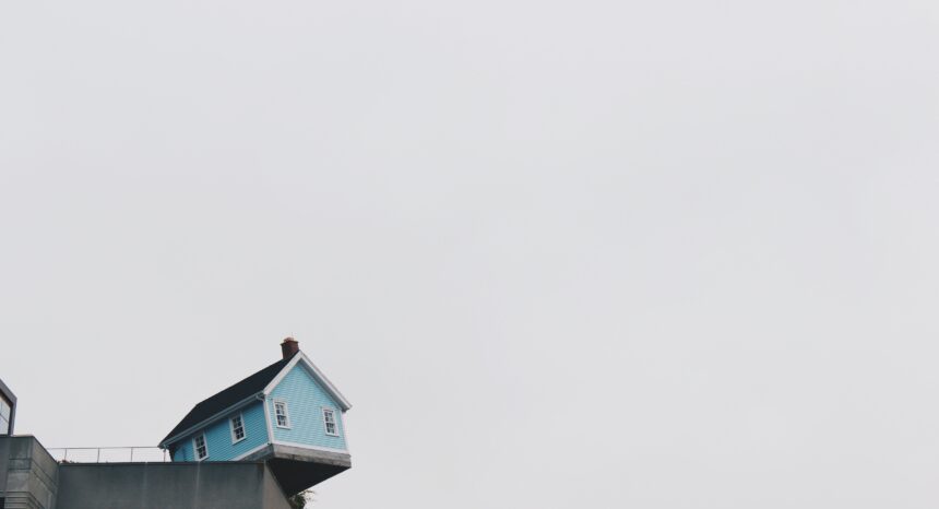 Image of a blue house on the edge of a concrete structure.