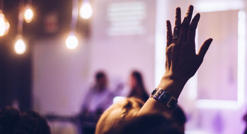 Photo of a raised hand in a conference.